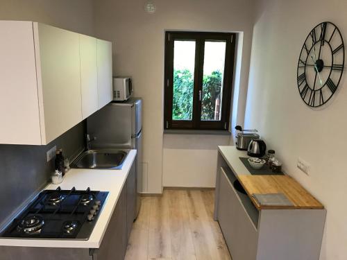 a kitchen with a stove and a sink and a clock at Home in Orvieto - Via dei Dolci in Orvieto