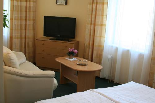 a living room with a couch and a tv and a table at Livonija in Sigulda