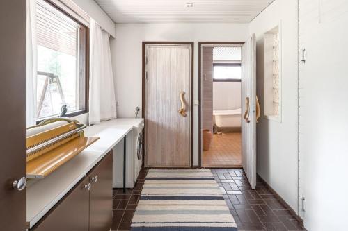 a hallway with a door and a bathroom with a tub at Villa Pulla - House Near Nature & City Center in Rovaniemi