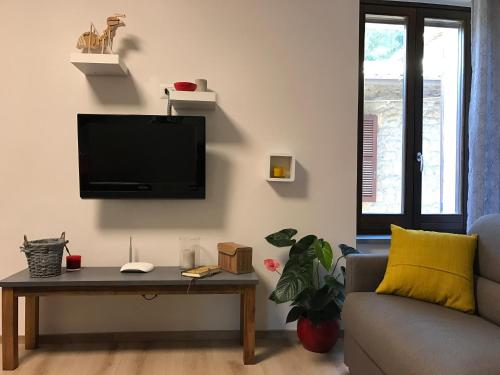 a living room with a couch and a tv on a wall at Home in Orvieto - Via dei Dolci in Orvieto