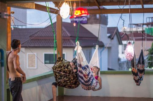 two boys are playing in hammocks in a house at Karma Home Hostel in Phitsanulok