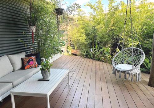 a patio with a couch and chairs on a wooden deck at Welcome to The Roy - Family home close to airport and train! in Melbourne