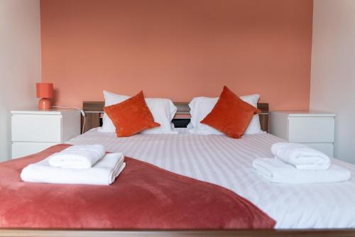 a bedroom with a large bed with towels on it at Spacious and Comfortable - 5 Bedroom Home in Kettering