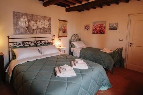 a bedroom with two beds with towels on them at Ca 18 rooms in Lucignano