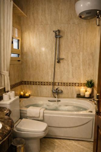 a bathroom with a tub and a toilet and a sink at The New Cairo 3BR Residence in Cairo