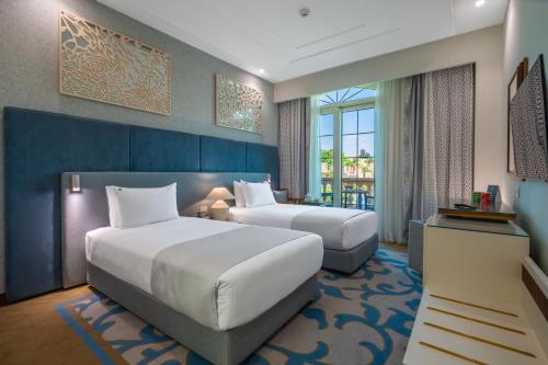 a hotel room with two beds and a window at Al Masa Hotel Nasr City in Cairo