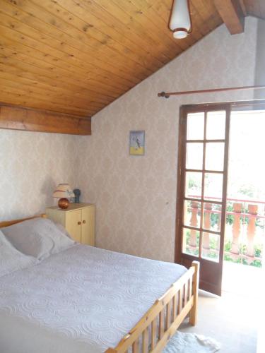 a bedroom with a bed and a large window at Vue exceptionnelle sur le lac in Lugrin