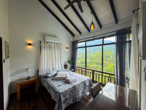 a bedroom with a bed and a large window at Jebat D'Manggis Janda Baik - Mountain View in Bentong