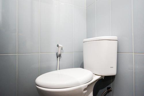 a white toilet in a bathroom with blue tiles at RedDoorz Plus @ Kalpataru in Rampal
