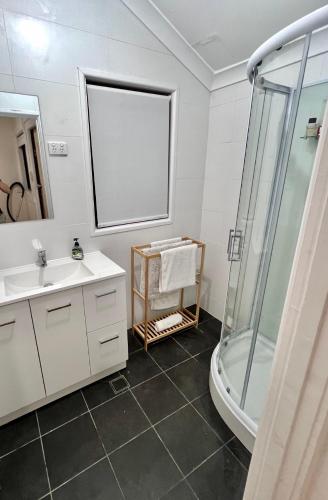 a bathroom with a sink and a shower at The Cottage in Queanbeyan