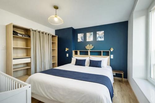 a bedroom with a large bed with blue walls at Au dôme de la basilique in Boulogne-sur-Mer
