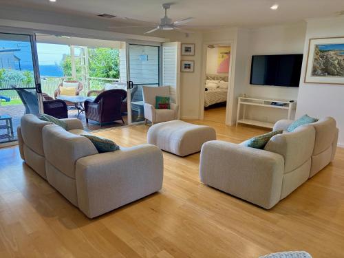 a living room with three couches and a television at Rose Villa - Port Willunga in Port Willunga