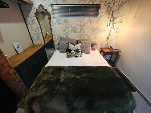 a bedroom with a large bed and a mirror at Otista Self-Catering Cottage Bloemfontein in Bloemfontein