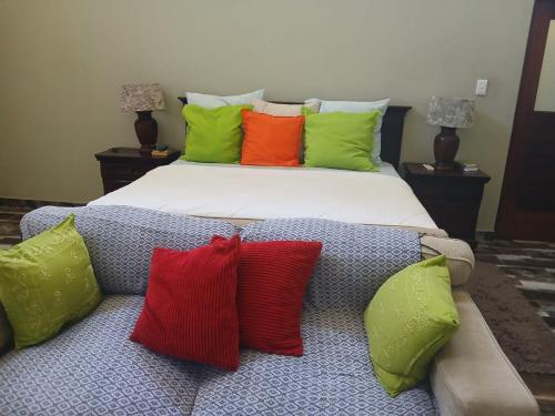 ein Bett mit bunten Kissen auf einem Sofa in der Unterkunft Ibokwe homested in Hillandale