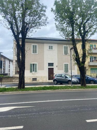 a building with two cars parked in front of a street at Villa Olivieri 1928 in Ascoli Piceno