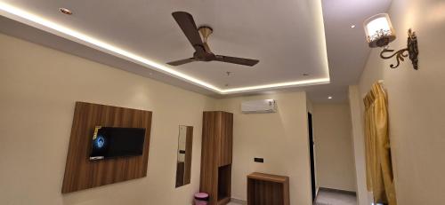 a ceiling fan in a living room with a tv at Hotel Sunrise Muzaffarpur in Muzaffarpur