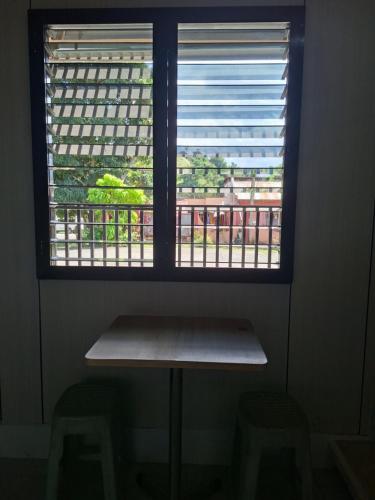a window with a table and two stools under it at Nancy's Place in Caniton