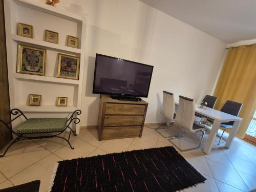 a living room with a television and a table and chairs at Monelly Apartman in Komárno