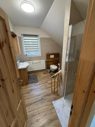 an attic bathroom with a toilet and a sink at Wellness chata Rybárie in Klokočov