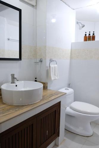 a white bathroom with a sink and a toilet at Sundown Resort & Austrian Pension House in Boracay