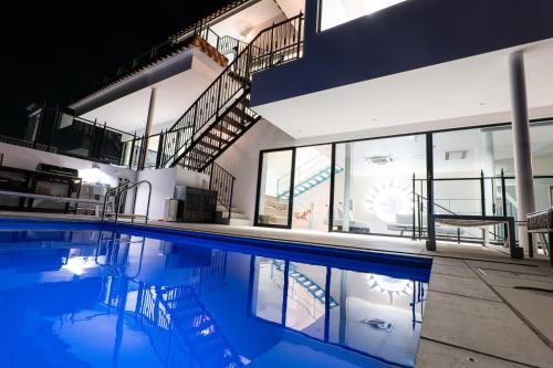 a swimming pool in a building with a house at villa costa del sol ヴィラ コスタ デル ソル 淡路島 in Awaji