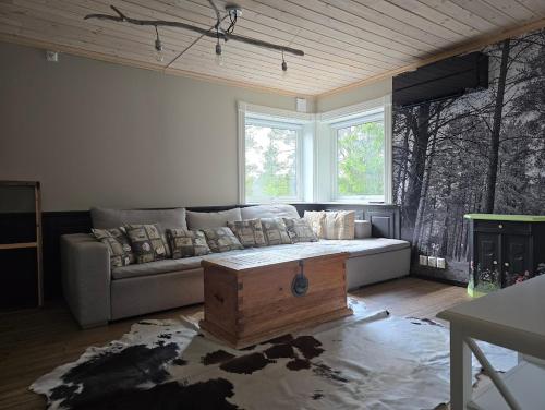 a living room with a couch and a large window at Fjellro appartment in Os