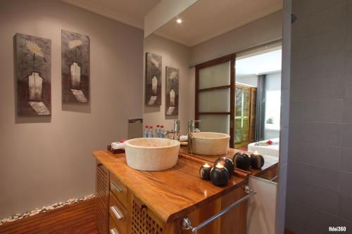 uma casa de banho com 2 lavatórios num balcão de madeira em Luxury Sakina Villa - Beachfront em Dzamandzar