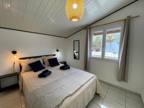 a bedroom with a large bed and a window at Les volets de l'océan in Saint-Philippe