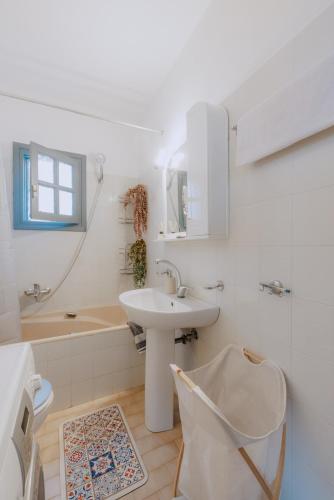 a white bathroom with a sink and a bath tub at Xiro Retreat in Xiropigado