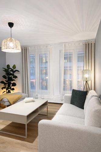 a living room with a white couch and a coffee table at Großzügiges Apartment am Limbecker Platz mit Cafés, Top Anbindung & Netflix in Essen