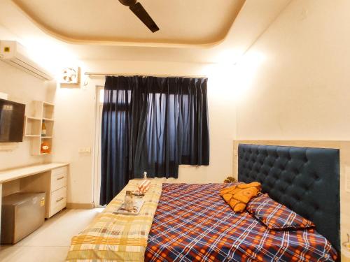 a bedroom with a bed with a blue headboard and a window at TIP TOP PG - Paying Guest in Phagwāra