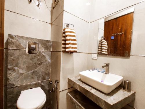 a bathroom with a sink and a toilet at TIP TOP PG - Paying Guest in Phagwāra