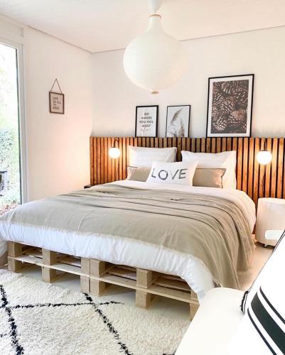 a bedroom with a large bed with a wooden headboard at Dromen op 1 - Stijlvol boshuis op de Veluwe met veranda en grote omheinde tuin! in Nunspeet