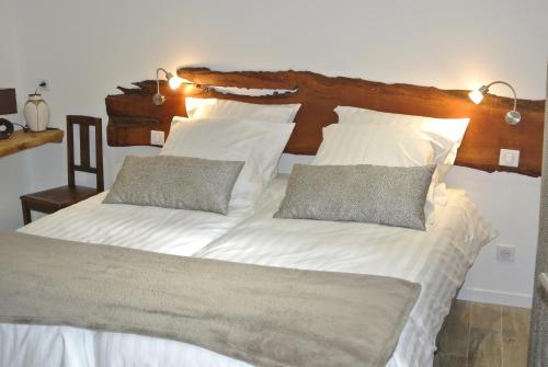 a large white bed with two pillows on it at Gite La Fixoune in Voegtlinshoffen