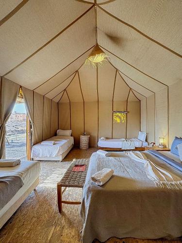 a room with two beds in a tent at Agafay, La Ferme Nomade Bivouac in El Karia