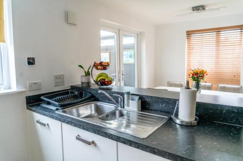 a kitchen with a sink and a counter top at Vyn's Holiday home - Sleeps 6 in Cardiff