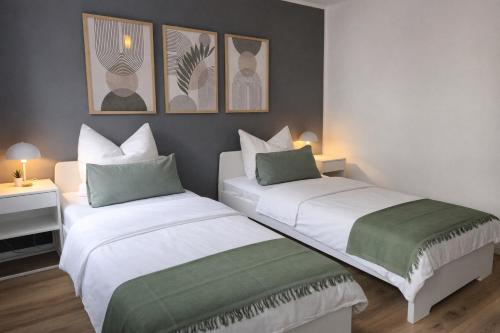 two beds in a room with two lamps and pictures on the wall at Großzügiges Apartment am Limbecker Platz mit Cafés, Top Anbindung & Netflix in Essen