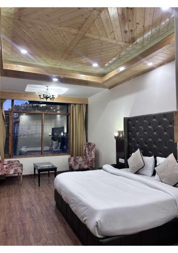 a bedroom with a large bed and a chair at Hotel De Park in Shimla