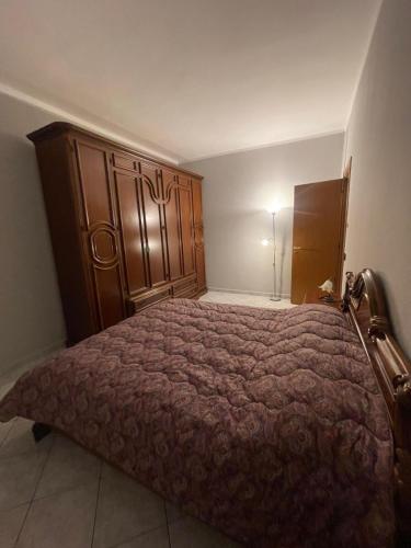 a bedroom with a large bed with a wooden headboard at La Vanitas in Cremona