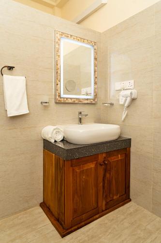 a bathroom with a sink and a mirror at Orchid Resort By Paradise in Habaraduwa Central