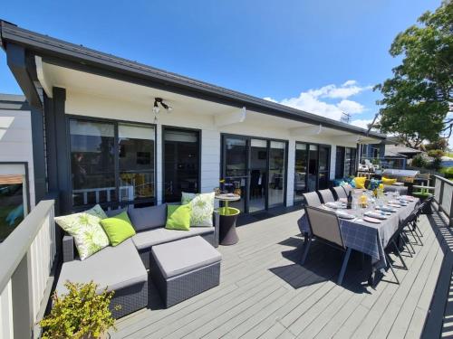 a patio with a couch and a table and chairs at Mollymook Beach Haven - near ocean & golf course in Mollymook