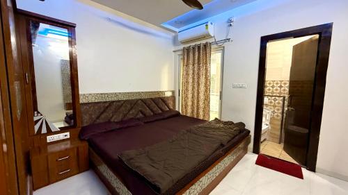 a small bedroom with a bed and a mirror at Shree Vaishnav Yatri Grah Near Mahakaleshwar Temple in Ujjain