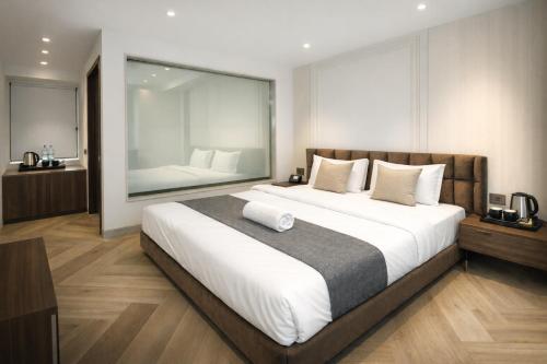 a bedroom with a large bed with a large mirror at Qotel Signature Coleman Janakpuri Near District Centre & Pacific Mall in New Delhi