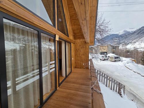 a house with a balcony with a view of the mountains at Lasha's Cottage in Mestia