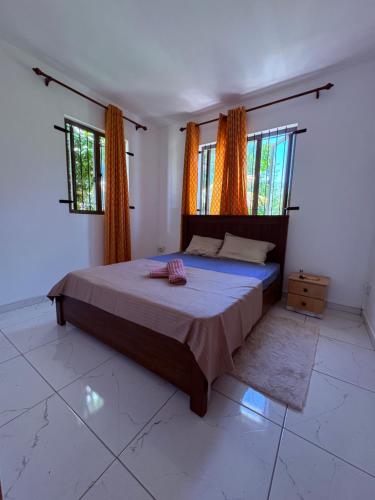 a bedroom with a bed and two windows at Cool Breeze Villa No 2 in Grand-Baie