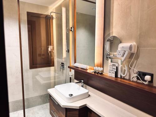 a bathroom with a sink and a mirror and a shower at فندق قرى Qira Hotel in Mecca