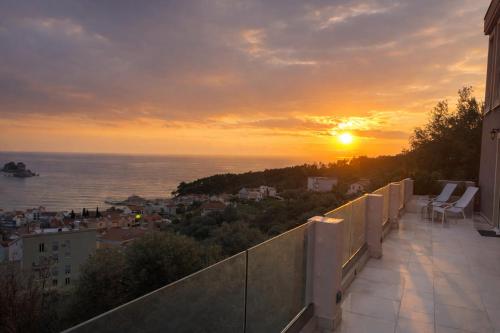 a view of the sunset from the balcony of a building at Villa Blue Vista Meerblick mit Jacuzzi in Petrovac na Moru