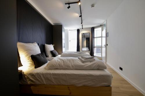 a bedroom with a large bed with white sheets and pillows at 3-2-1meins Röntgen bis 3 Pers DTV 4 Sterne Parkplatz WLAN Self Check-in in Remscheid