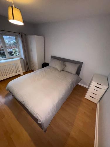 a bedroom with a large white bed and a window at Cosy room 4 T Gatwick in Crawley