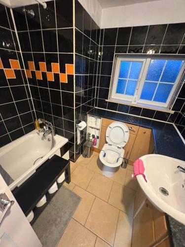 a bathroom with a toilet and a tub and a sink at Cosy room 4 T Gatwick in Crawley